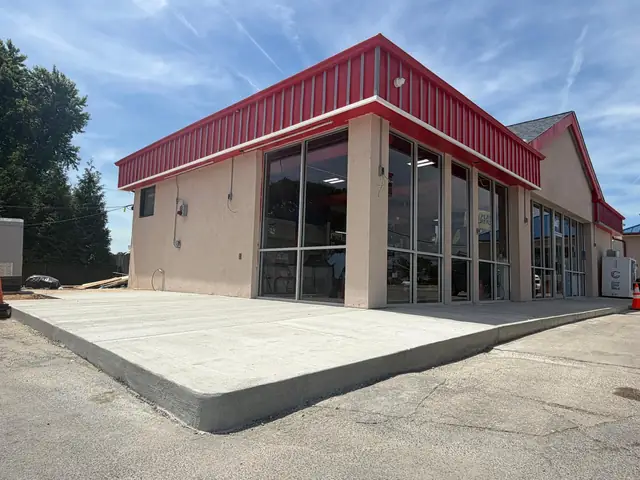 Newly poured concrete apron and curb beside the building