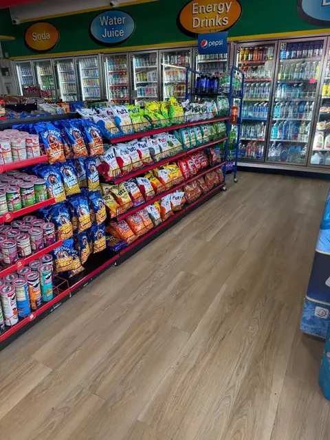 Cooler line stocked with drinks beside the snack aisle