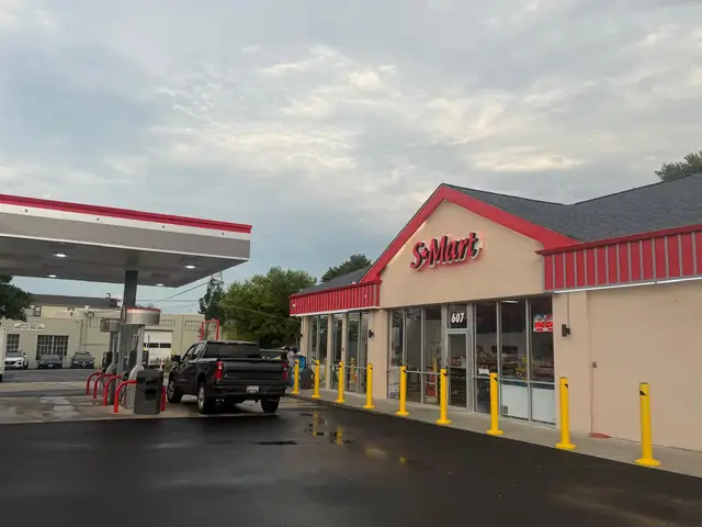 Store and fuel canopy with a customer at the pumps